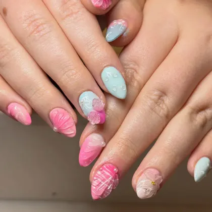 Pastel pink and blue almond nails with raised 3D flowers and shells